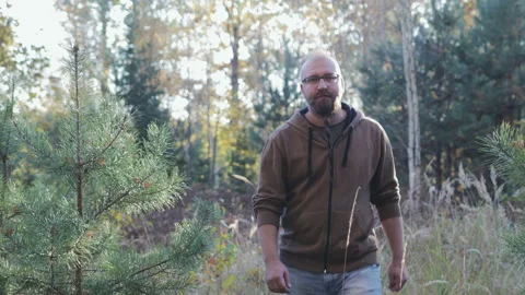 A young guy walks through the woods and enjoys the fresh air 스톡 동영상 100725876