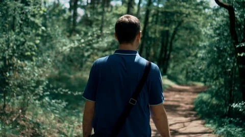 Young guy walks through the woods in the park Stock Footage 107846681