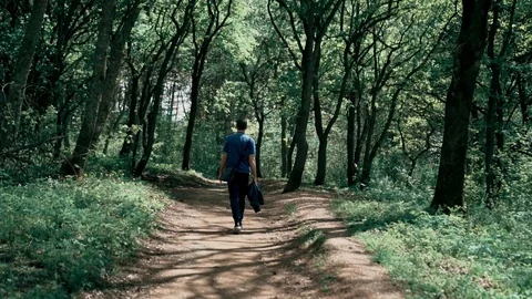 Young guy walks through the woods in the park Vidéo 107846685