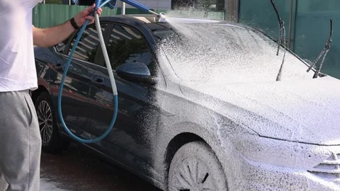 Young guy washes car with foam Stock Footage 309755167