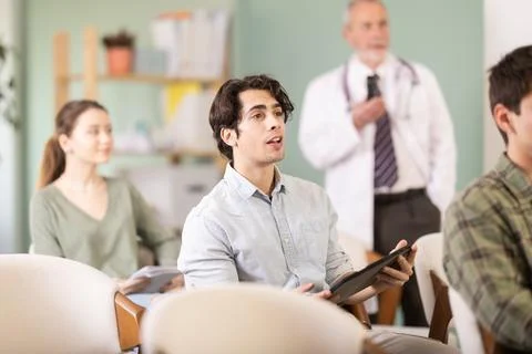 Young guy watching presentation with a doctor standing in background Stock Photos
