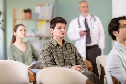 Young guy watching presentation with a doctor standing in background Stock Photos
