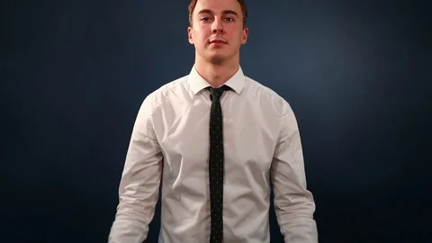 Young guy in white shirt claps his hands on a dark blue background Stock Footage 72372152