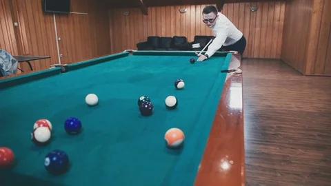 Young guy in a white shirt plays billiards Stock Footage 81476569