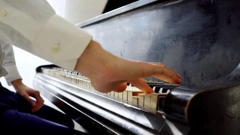 Young guy in white shirt plays classical music on the piano Stock Footage 295703402