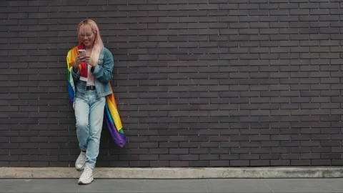 Young Guy in a Wig and Stylishly Dressed Is Standing, Leaning Against the Wall Video stock 270966421