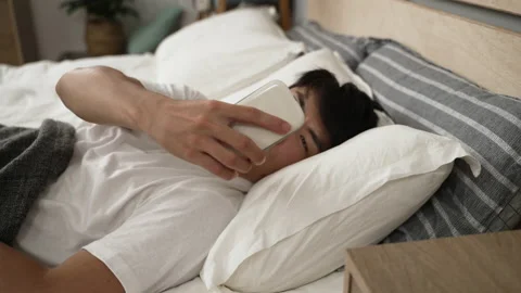 Young guy woken by alarm clock triggered 스톡 동영상 211658438
