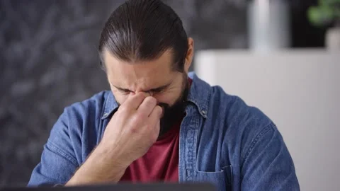 Young guy worker freelancer working at laptop typing tired rubbing eyes yawning Stock Footage 236588665