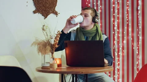 Young guy working at cafe. Man enjoying coffee while browsing laptop. Young Stock Footage 335410560