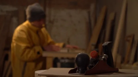 Young guy working in his workshop. Grinding wood Stock Footage 125859144