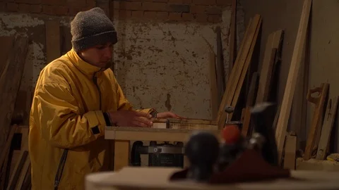 Young guy working in his workshop. Grinding wood Stock Footage 125859225