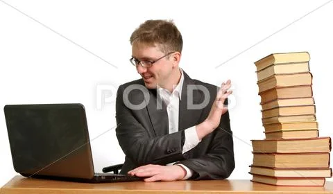 Young guy working at a laptop and shrugs off paper books Stock Photos