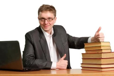 Young guy working at a laptop shows a thumbs-up gesture to say that paper boo Stock Photos