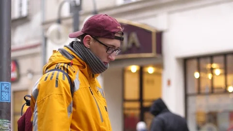The young guy in yellow jacket stay on street type mobile phone chatting social Stock Footage 84520217