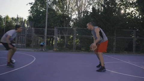 Young guys are training to play on the playground in basketball score goals Stock Footage 110617979
