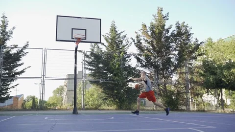 Young guys are training to play on the playground in basketball score goals Stock Footage 110618014