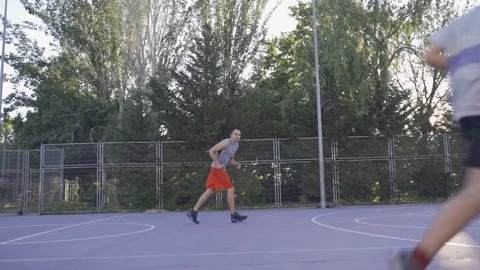 Young guys are training to play on the playground in basketball score goals Stock Footage 110618044