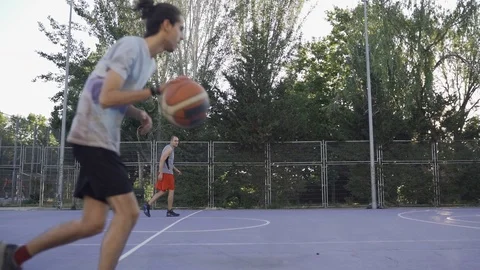 Young guys are training to play on the playground in basketball score goals Stock Footage 110618059