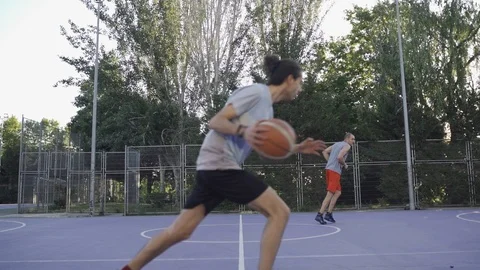 Young guys are training to play on the playground in basketball score goals Stock Footage 110618064