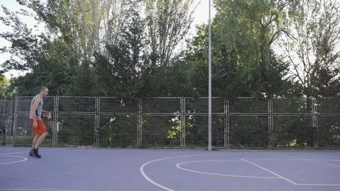 Young guys are training to play on the playground in basketball score goals Stock Footage 110618079