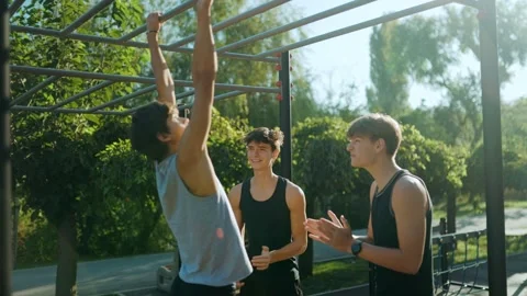 Young guys celebrating after intense pull ups at the fitness ground. Stock Footage 346140910