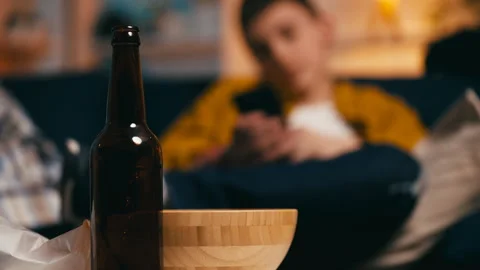Young guys drinking beer and using smartphones at home, underage drinking Stock Footage 251806796