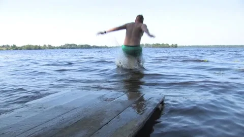 Young guys jump in the summer from the platform into the water Video stock 94187230