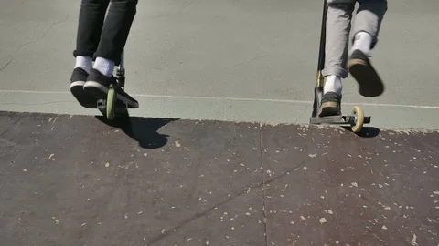 Young guys jumping and doing tricks on a scooter in a skatepark Vidéo 94142545