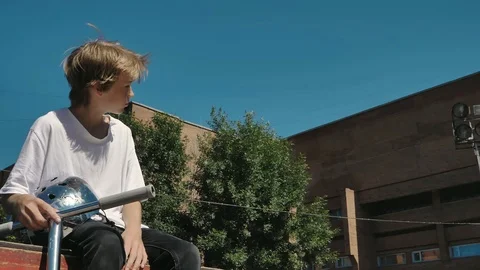 Young guys jumping and doing tricks on a scooter in a skatepark Stock-Footage 94142741