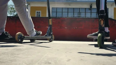 Young guys jumping and doing tricks on a scooter in a skatepark Video stock 94142820