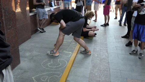 Young guys - students draw, graphics, depict letters on the path with crayons. Stock Footage 134259580