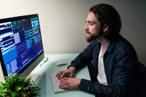 Young hacker in the dark breaks the access to steal information and infect co Stock Photos