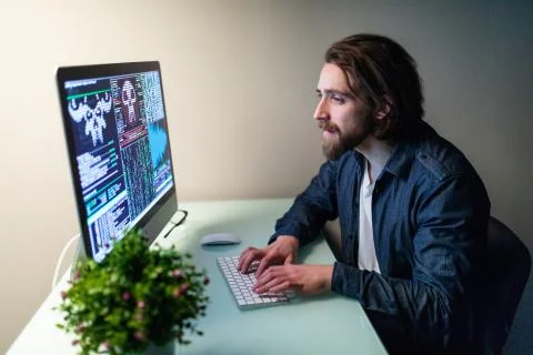 Young hacker in the dark breaks the access to steal information and infect co Stock Photos