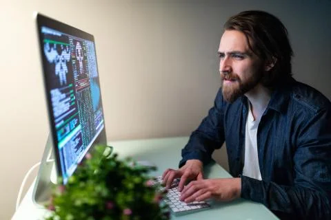 Young hacker in the dark breaks the access to steal information and infect co Stock Photos