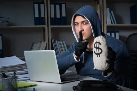 Young hacker hacking into computer at night Stock Photos
