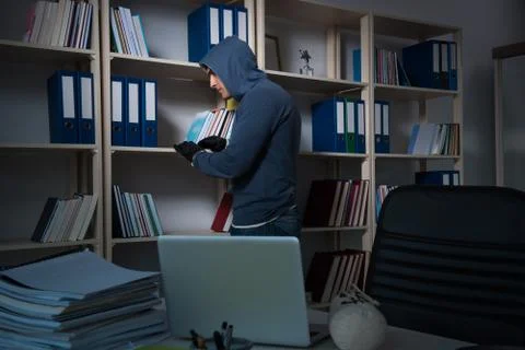 Young hacker hacking into computer at night Stock Photos