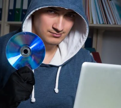 Young hacker hacking into computer at night Stock Photos