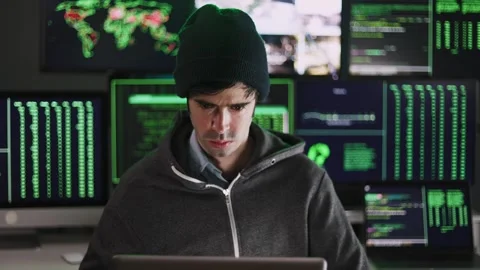 Young hacker man breaking into corporate servers from his home office Stock Footage 310505631