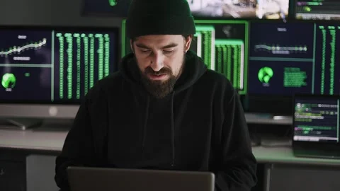 Young hacker man breaking into corporate servers from his home office Stock Footage 310505860