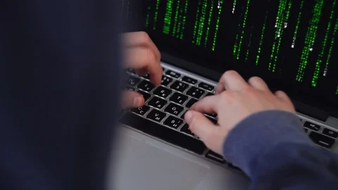 Young Hacker typing on laptop computer, coding. Boy in hood sits at table. Lapto Stock Footage 100303953
