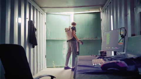 Young hacker working in a secret industrial container hideout Stock Footage 341662744