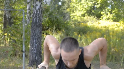 Young half-naked man does exercise on parallel bars in park Stock Footage 67481871