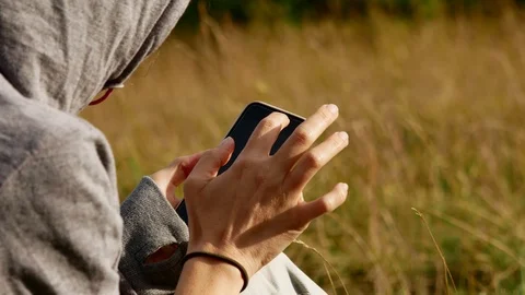 Young hand holds and using smartphone in nature. 4k 動画素材 116161213