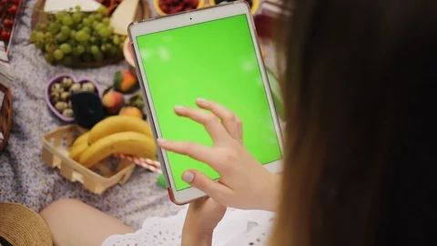 Young hand woman using a tablet computer with green screen background on a Stock Footage 92870380