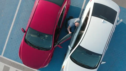 Young handicapped driver getting in red car from wheelchair Stock Footage 160459068