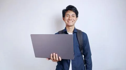 Young handsome Asian man is happy holding a laptop 写真素材