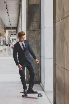 Young handsome Asian model posing with his skateboard Stock Photos