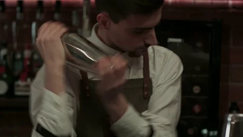 Young handsome barman in bar interior shaking and mixing alcohol cocktail Vídeos de archivo 73686214
