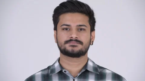 Young handsome bearded Indian man covering ears as three wise monkeys concept Video stock 101520962