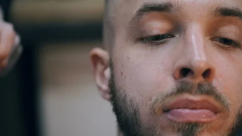 Young handsome bearded man getting a haircut in a modern barber shop. Видео 86477838